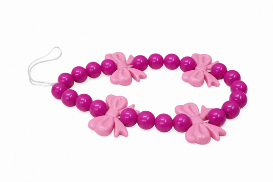 Pink beaded necklace with butterfly charms on a white background